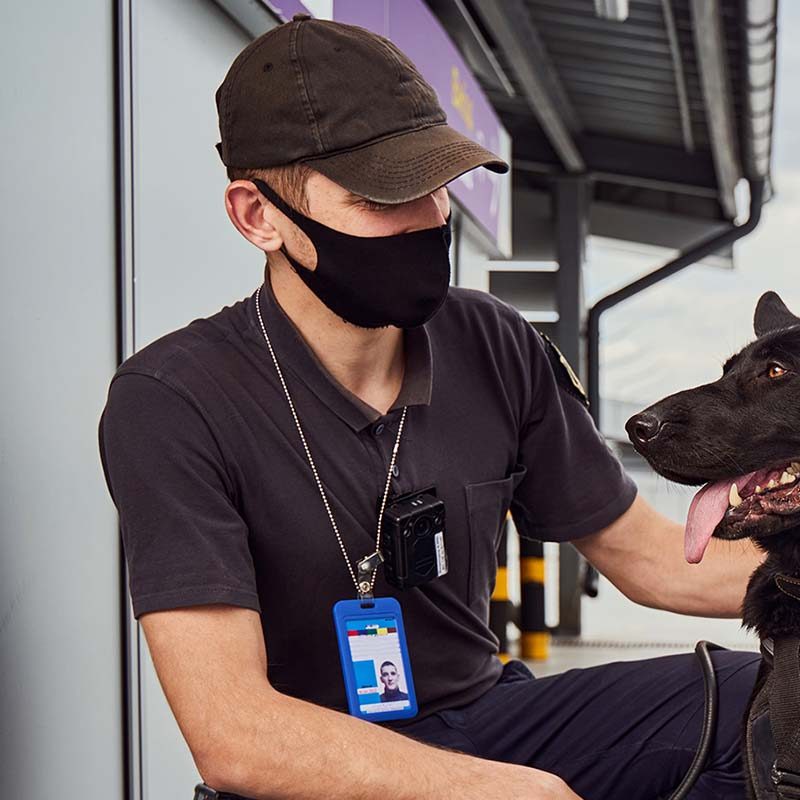 male-security-officer-petting-detection-dog-at-air-KKV3SNR.jpg